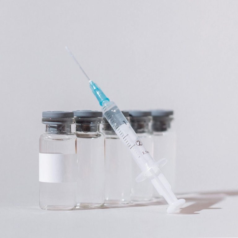 A white neon light in the outline of letters spelling "FOR THE WORLD" is attached to a dark wall